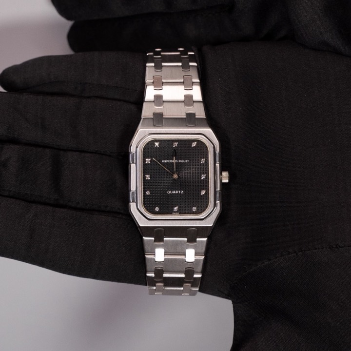 Orologio Audemars Piguet in acciaio tenuto da una mano in guanto nero, Chiossone Luxury Watches